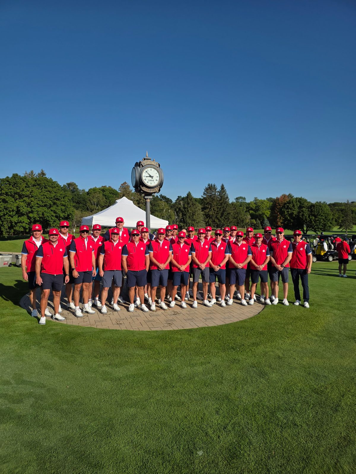 Wide shot of Team Nakoma at the clock under a clear sky
