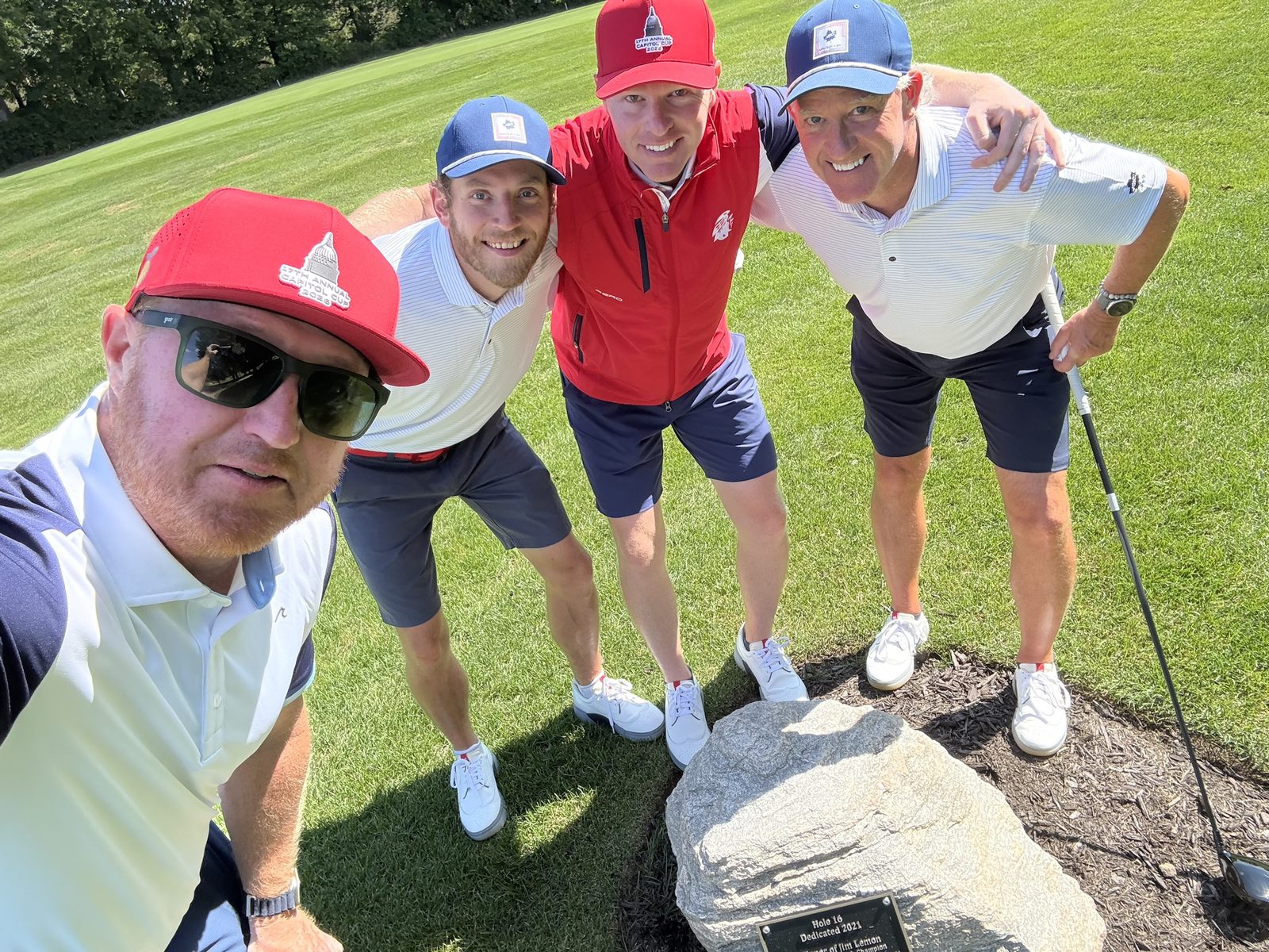 Foursome at the Hole 16 memorial rock