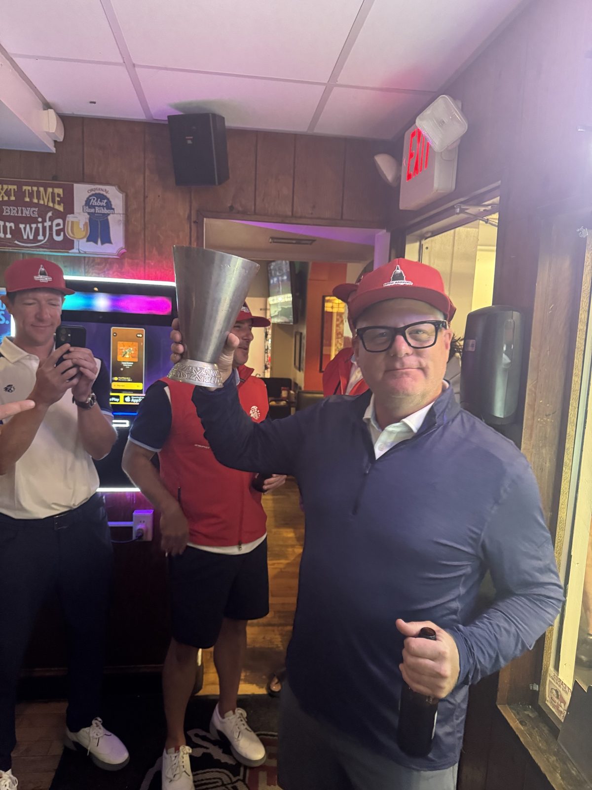 Player holding the Capitol Cup trophy at the bar